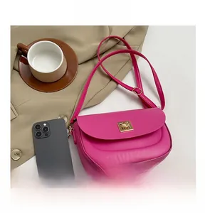 Vue détaillée du sac besace fuchsia avec boucle en métal doré et taille de smartphone