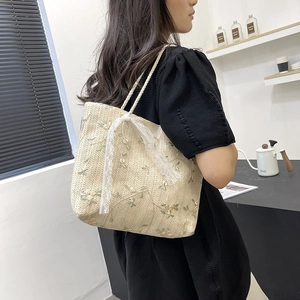 Straw tote bag with floral embroidery and white lace bow for summer beach outings