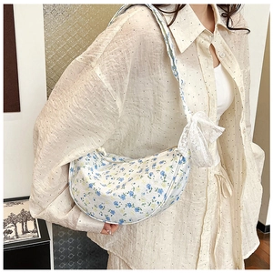 Detailed shot of floral canvas crescent bag with white lace bow on shoulder strap