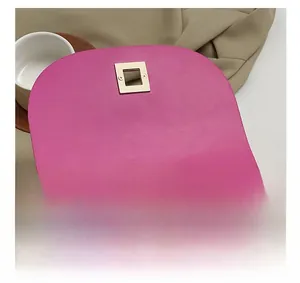 Détail du sac de selle rose rouge montrant le fermoir pivotant en métal doré et le zip