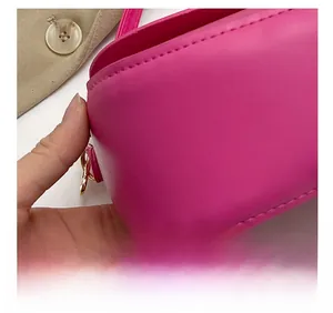 Détails de la sacoche rose fuchsia avec surpiqûres précises et attaches en métal doré