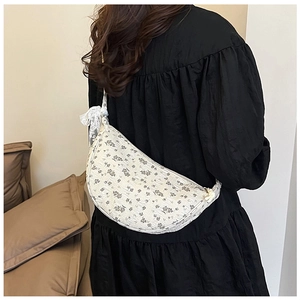 Floral canvas crescent bag detail with lace bow and pleated texture on white fabric