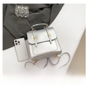 Silver metallic mini backpack detail showing size comparison with a white smartphone