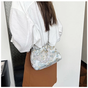 Detail of embroidered butterfly crossbody bag with beaded handle and chain strap