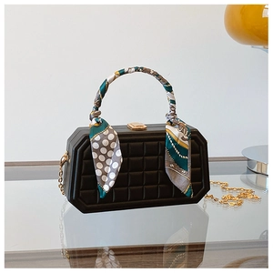 Detail of black box handbag featuring geometric lattice texture and colorful silk scarf handle
