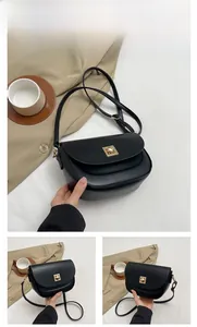 Gros plan d'un sac besace noir en cuir avec un fermoir géométrique en métal doré