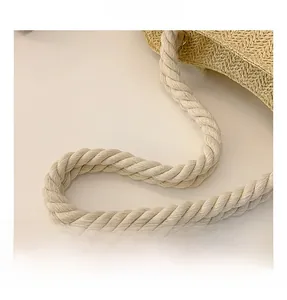 Detail of sturdy cream-colored twisted rope handles and fine woven texture on the straw bag