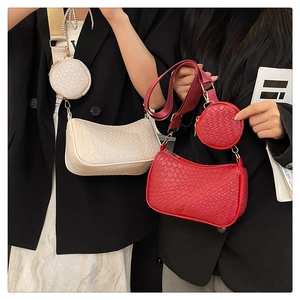 Détail de sacs baguette rouge et crème avec texture crocodile et petit porte-monnaie