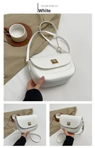 Détail du sac de selle blanc avec un fermoir rotatif carré en métal doré