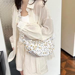 Chic floral canvas crescent bag shown on model for a stylish summer outfit look