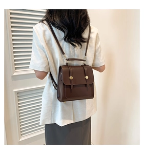 Detail view of vintage dark brown faux leather backpack with metallic buckle closures