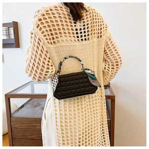 Detail of black plaid box bag with silk scarf wrapped handle and gold chain strap