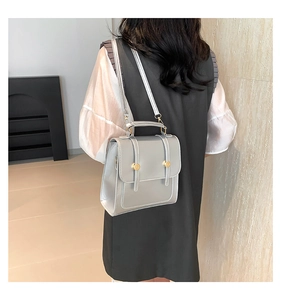 Silver-grey rectangle flap handbag worn by model showing a stylish minimalist back view