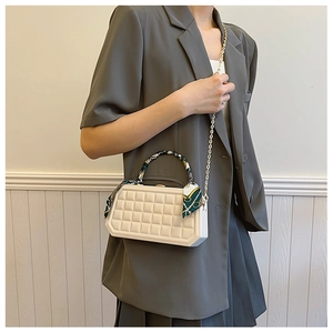 Plaid pattern box handbag with a silk scarf handle and gold chain strap on grey suit