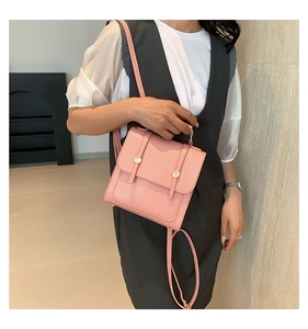 Detailed view of pale pink backpack with golden hardware and fashionable square design