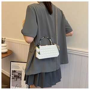 White quilted chain crossbody bag with silk scarf handle on grey blazer model