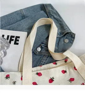 Détail du sac fourre-tout en velours côtelé blanc avec imprimé fraise et anses