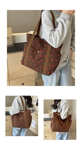Détail d'un sac cabas en velours côtelé marron avec broderie fraise rouge et texture riche