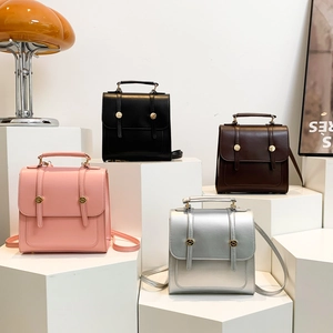 Minimalist college style backpacks in pink, black, brown and silver on white geometric stands