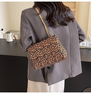 Sac bandoulière imprimé léopard avec chaîne dorée porté par un mannequin chic