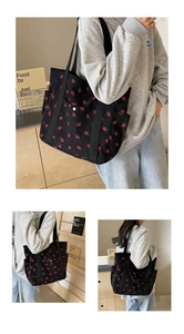 Détail du sac cabas noir en velours côtelé avec broderie fraises et poches de côté