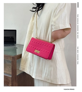 Détail du sac matelassé rose fuchsia avec bandoulière chaîne dorée et fermoir rotatif