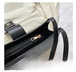 Détail de la fermeture éclair dorée lisse sur le sac à bandoulière tissé bleu et blanc