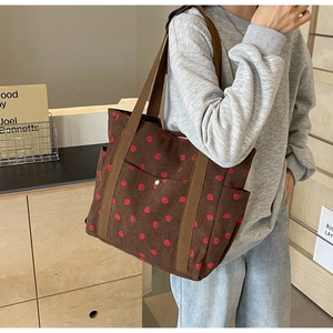 Vue détaillée du sac cabas en velours côtelé imprimé fraises avec plusieurs poches