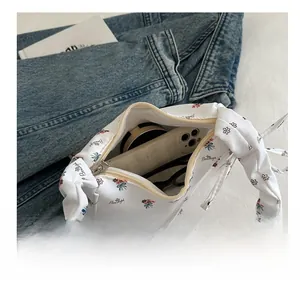 Internal view of floral print canvas shoulder bag holding phone and cosmetics