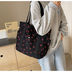 Détail du grand sac cabas en velours côtelé noir avec imprimé fraise rouge et anses