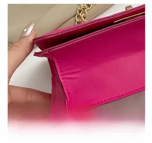 Détail de la couture précise sur le côté d'un sac à bandoulière matelassé rouge rose