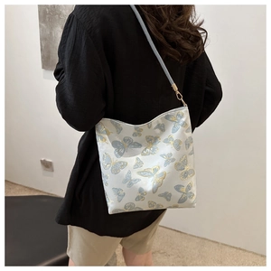 Detail of light blue butterfly jacquard fabric and gold buckle on a chic shoulder bag