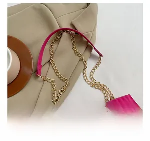 Détail du sac matelassé rose fuchsia montrant la bandoulière chaîne et l'anse en cuir