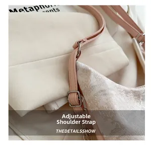 Detail of adjustable leather strap and metal buckle on floral jacquard tote bag