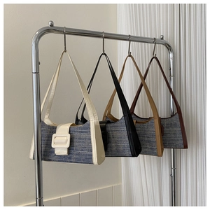 Sacs baguette vintage en denim de quatre couleurs suspendus sur un présentoir