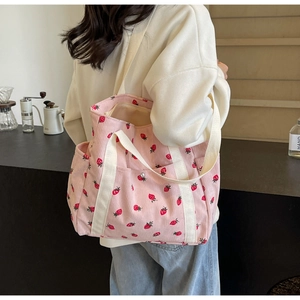 Détail du sac cabas en velours côtelé rose avec imprimé fraises et poche latérale