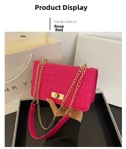 Détail macro du sac matelassé rose rouge avec chaîne dorée et fermoir métallique