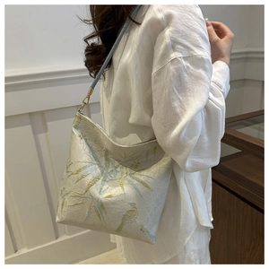 Detail of silk bamboo embroidery and bird pattern on an elegant oriental shoulder bag