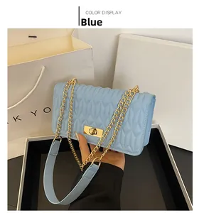 Détail du sac à main matelassé bleu clair avec motif en V et fermoir doré rotatif