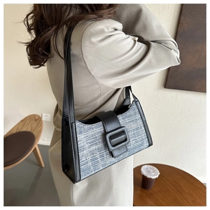 Sac sous le bras en tweed bleu-gris avec grande boucle noire et bandoulière sur modèle