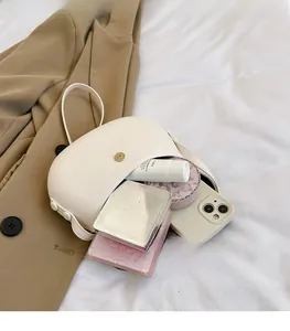 Interior storage of white saddle bag showing space for phone and makeup items