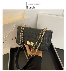 Détail du sac matelassé noir avec serrure dorée rotative et bandoulière en chaîne