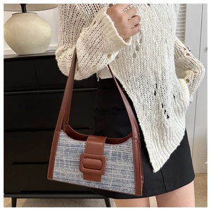 Détail du sac d'épaule en denim tweed avec garniture en cuir et boucle décorative