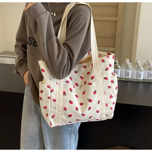 Détail du sac cabas en velours côtelé blanc avec motif fraise et poche latérale