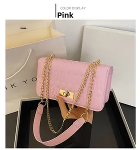 Détail d'un sac à bandoulière rose matelassé avec motif coeur et fermoir doré