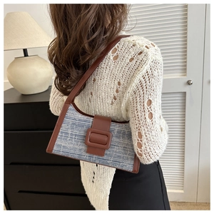 Détail du sac sous le bras en tweed avec tissu bleu et boucle de sangle en cuir brun
