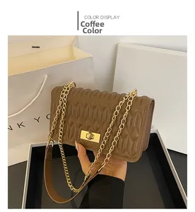 Détail du sac bandoulière matelassé marron avec fermoir rotatif doré et chaîne chic