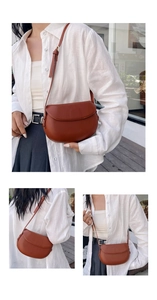 Detailed close-up showing the smooth leather texture and rounded saddle shape of the brown bag