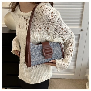 Détail d'un sac baguette rétro en tweed bleu et cuir marron au design chic et minimaliste