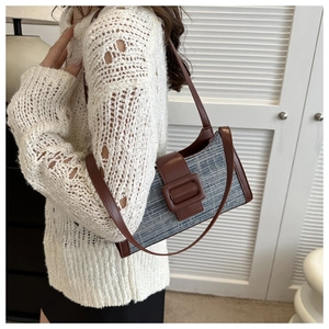 Détail d'un sac baguette en tweed bleu et cuir marron avec boucle décorative élégante